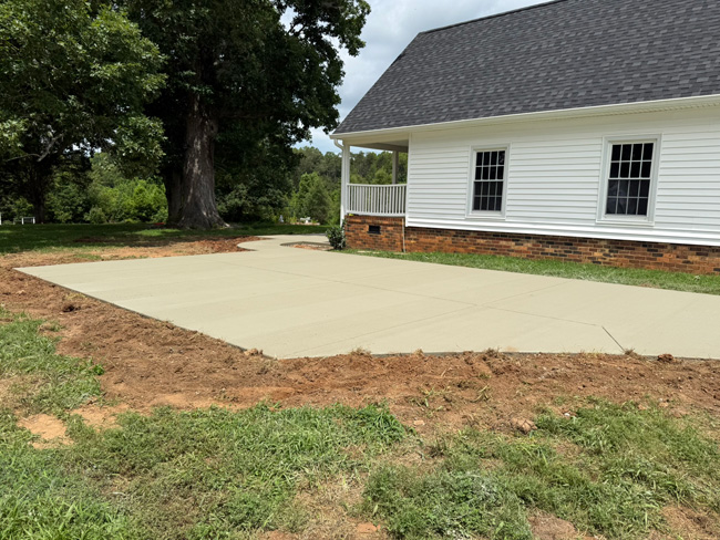 JT Contracting Concrete work - Concrete driveway and parking area with walkway to patio