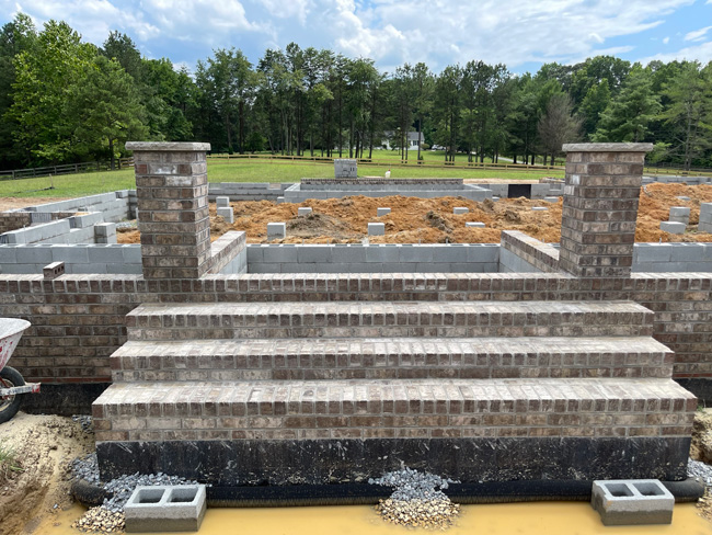 Masonry foundation being built with blocks and bricks for a new home build